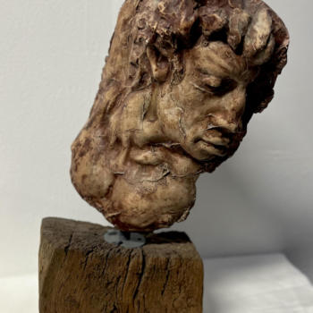 Scultura in gesso, con base in tronco d'albero, raffigurante il volto di un uomo.